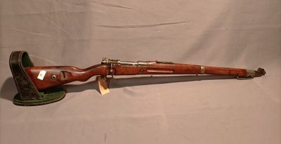 un vieux fusil avec un canon en bois et des accessoires en laiton