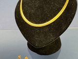 un collier et des boucles d'oreilles exposés dans une vitrine