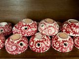 plusieurs vases rouges et blancs posés sur une étagère en bois