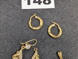 Trois paires de boucles d'oreilles et un collier sont exposés sur une table