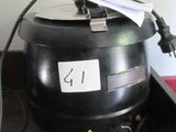 un pot noir recouvert d'un papier, posé sur une table