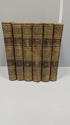 un lot de cinq vieux livres posés sur une table blanche