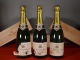 deux bouteilles de champagne posées à côté d'une caisse en bois sur une table