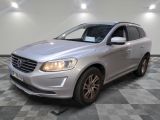 Le SUV Volvo argenté est garé sur un sol en carrelage à damier.