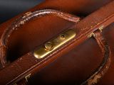 a close up of a brown leather bag with a handle