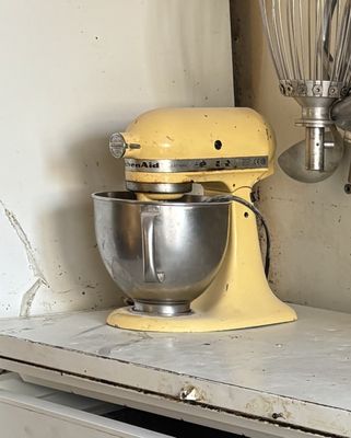 a yellow mixer and a whisk in a kitchen