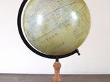 un vieux globe terrestre posé sur une table en bois, à côté d'un miroir