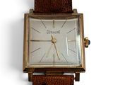 une montre montée sur un bracelet en cuir marron
