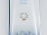 a close up of a ring in a package on a white surface