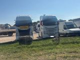 many trucks that are parked next to each other in the grass