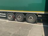 a green semi truck that is parked on the side of the road