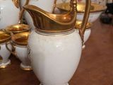 many white and gold vases sitting on a wooden table