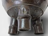 a large metal pot with a bird on it