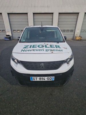 une camionnette blanche garée devant un bâtiment