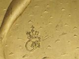 a gold plate with a picture of a woman ' s foot and a ring on it