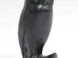une image représentant une statue de chouette perchée sur une souche d'arbre