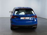the rear end of a blue car parked in a white room