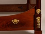 a bed with a wooden frame and gold decorations on the headboard