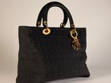 a black handbag with gold hardware and a chain on the handle