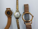 Trois montres sont posées les unes à côté des autres sur une table.