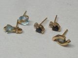 trois paires de boucles d'oreilles à clous en or et pierres bleues sur un fond blanc