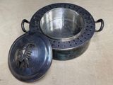 a metal bowl with a lid that has a design on it