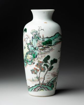 un vase blanc avec un tableau posé sur une table