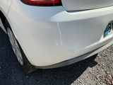 a white car that is parked on the side of the road