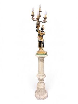 a statue of a man and a woman holding a candelabra