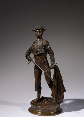 bronze statue of a bullfighter with a cape and a sword