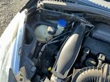 un moteur de voiture dont le capot est ouvert et dans lequel se trouve une bouteille d'eau