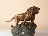 bronze statue of a lion on a rock on a table