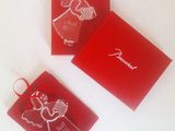 three christmas ornaments in red boxes on a white surface