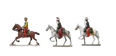 trois figurines représentant des hommes à cheval sur un fond blanc