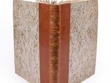 an old book with a brown cover on a white background