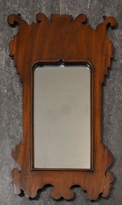 a wooden mirror hanging on the wall next to a wall