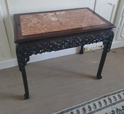 une petite table avec un plateau en marbre dans une pièce