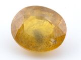 gros plan d'une pierre de saphir jaune sur une surface blanche