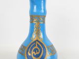 a blue and gold vase sitting on a white surface