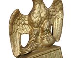 golden statue of a bird with a crown on top of a sign