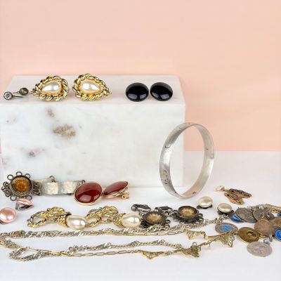 une boîte en marbre blanc sur laquelle sont disposés plusieurs bijoux