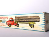 a red truck with a large log on the back of it
