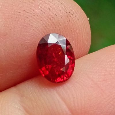 un gros plan d'un diamant rouge au doigt d'une personne