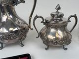 a silver tea pot and a silver tea pot on a table