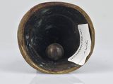 a small vase with a tag on it sitting on a table