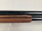 a close up of a shotgun with a wooden handle