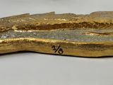 two gold colored shoes are sitting next to each other on a white surface