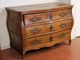 a wooden chest of drawers in the corner of a room