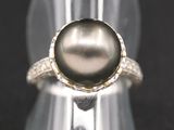 un gros plan d'une bague en argent ornée d'une perle noire