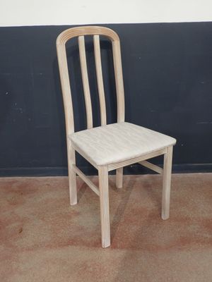 a wooden chair sitting in front of a black wall